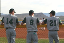 Craig Brimhall, Jason Cherry, and Spencer Hutchings stand against fence before game